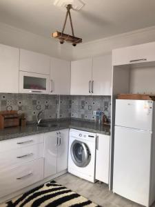 a white kitchen with a washer and dryer in it at mumcular apartment in Bodrum City