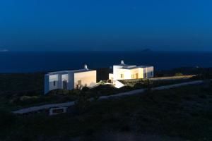two white buildings on a hill with the ocean at Aeraki in Kithnos +20 photos