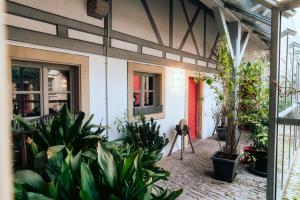 a patio with plants and a red door at Weinbar & Gästehaus Himmelstoss in Dettelbach