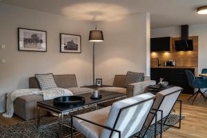 un soggiorno con divano, tavolo e sedie di Suite Home Apartments a Weimar