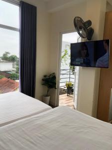 a bedroom with a bed and a tv on the wall at Hue Four Seasons Hotel in Hue