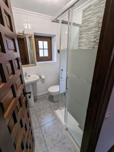 a bathroom with a glass shower and a toilet at Posada Revolgo in Santillana del Mar