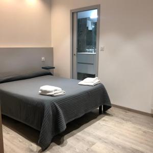 a bedroom with a bed with two towels on it at Hotel le Dauphin in Ajaccio