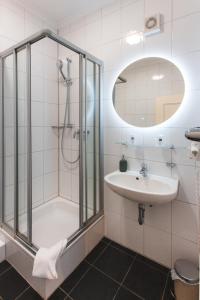 a bathroom with a shower and a sink at Hotel Restaurant Am Park in Waltrop