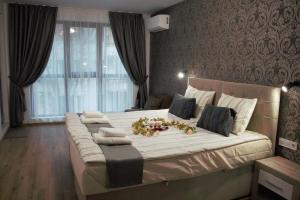 a bedroom with a large bed with flowers on it at ARIAL -Топ Център Варна in Varna City