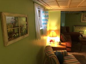 a living room with a couch and a table with a lamp at Rustic BEACH FRONT Basement Apt, Pet Friendly Wi-Fi apts in North Camellia Acres