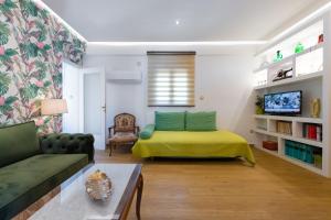 ein Wohnzimmer mit einem grünen Bett und einem Sofa in der Unterkunft Vintage Boutique Penthouse in Piräus