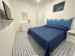 Un dormitorio con una cama azul y un suelo blanco. en CANNETO BLU, en Lipari