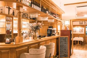 a restaurant with a bar with chairs and a counter at Hotel Restaurant Am Park in Waltrop