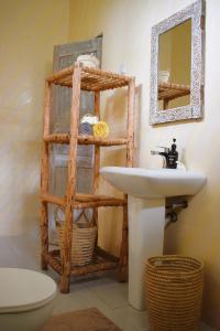 bagno con lavandino e specchio di Maryam Garden Apartments & Villa a Bwejuu