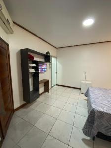 a bedroom with a bed and a tv on a wall at Alter Villa Suítes in Alter do Chao