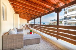 balkon z kanapą i krzesłami w budynku w obiekcie Vintage Boutique Penthouse w Pireusie