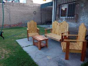 2 sillas de madera y un banco en un patio en Alojamiento Comodoro en San Rafael