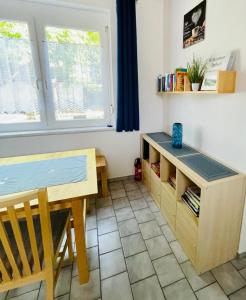 Habitación con escritorio, mesa, mesa y ventana. en Ferienwohnung Rosenauer en Purbach am Neusiedlersee