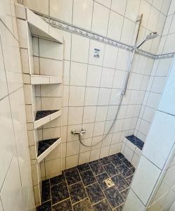 uma casa de banho com um chuveiro com azulejos brancos em Ferienwohnung Rosenauer em Purbach am Neusiedlersee