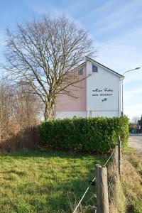 una señal en el lado de un edificio con un árbol en Haus Fabry, en Hilden