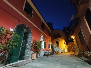 un callejón con un edificio rojo con una puerta verde en Boutique Hotel Novecento, en La Spezia