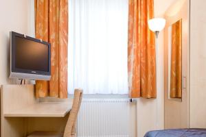 een kamer met een televisie op een bureau en een raam bij Haus Fabry in Hilden