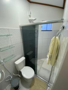 a bathroom with a toilet and a glass shower at Alter Villa Suítes in Alter do Chao