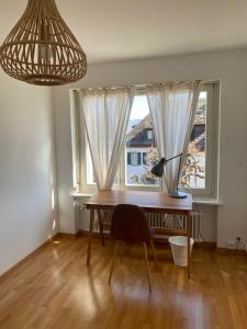 a desk with a lamp in a room with a window at Bethaniaweg in Rüschlikon