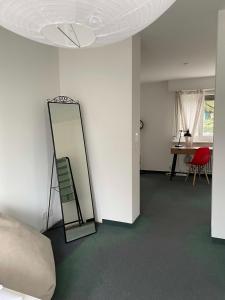 Zimmer mit einem Spiegel an der Wand und einem Tisch in der Unterkunft Bethaniaweg in Rüschlikon