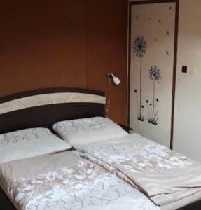 a bed with white sheets and flowers painted on the wall at Záboj restaurant in Karlovy Vary
