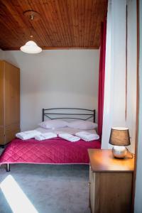 una camera con un letto con una coperta rossa di Studio Sevasti a Kala Nera