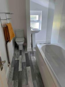 uma casa de banho com uma banheira, um WC e um lavatório. em Chic & Cosy Studio Apartment em Southampton