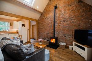 a living room with a brick wall and a fireplace at White House Barn, near Yarm / Stockton-on-Tees in Yarm