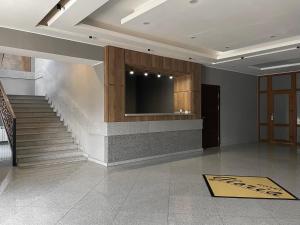 a lobby with stairs and a television on the wall at Hotel Gloria Deluxe in Borovoye