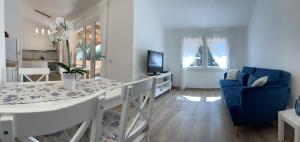 a living room with a table and a blue chair at Beach House Calaverde Village in Santa Margherita di Pula