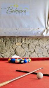 a pool table with balls and cue sticks on it at Pousada Belmare Eireli in Rio das Ostras