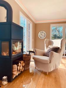 a living room with a fireplace and a chair at Landhaus Eggert in Münster