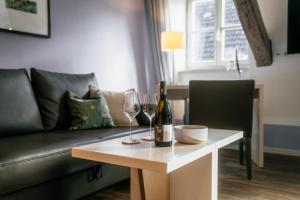 a living room with a couch and a table with wine glasses at Weinbar & Gästehaus Himmelstoss in Dettelbach