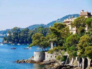 RAGGIO DI SOLE - pool, tennis, parking, sea view & relax في رابالو: قلعة على شاطيء تجمع المياه