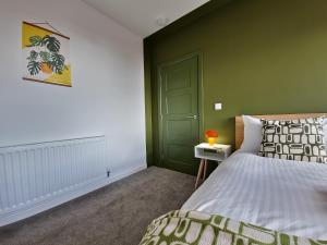 a bedroom with a bed and a green wall at Apartment Two - private car park, comfortable and well equipped - by Ocean City Retreats in Plymouth