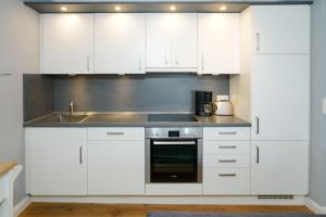 eine Küche mit weißen Schränken und einem Waschbecken in der Unterkunft Haus Strandburg, Wohnung17, 25980 Westerland in Westerland
