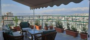 een balkon met tafels en stoelen en uitzicht op de stad bij Taratsaki in Athene