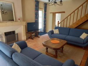a living room with blue couches and a fireplace at Gîte Saumurois 7 personnes in Montreuil-Bellay