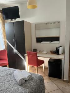 a bedroom with a desk and a red chair and a bed at Cascina Graziosa in Lonato