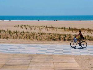 um rapaz a andar de bicicleta na praia em Nuevo apartamento en la playa de Castelldefels! em Castelldefels