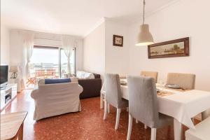 Apartment Muralla في فيلاسار دي مار: غرفة معيشة مع طاولة طعام وكراسي