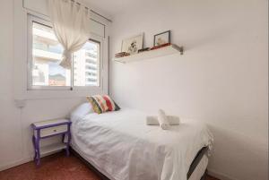 a small bedroom with a bed and a window at Apartment Muralla in Vilassar de Mar +20 photos