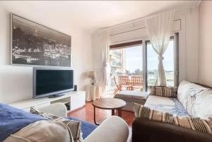 sala de estar con sofá y TV en Apartment Muralla en Vilassar de Mar