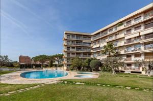 um grande edifício de apartamentos com uma piscina em frente em Apartment Muralla em Vilassar de Mar