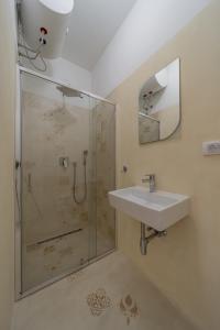 uma casa de banho com um chuveiro, um lavatório e um espelho. em BG Exclusive Suites em Belgrado
