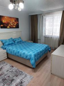 Un dormitorio con una cama azul y una ventana en Tarabya Family Suıt Boğaziçi, en Estambul