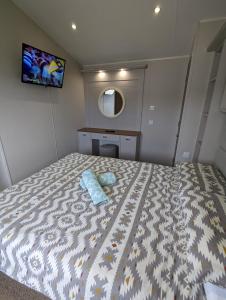 a bedroom with a bed with a blue towel on it at LOCATION LOCATION Beautiful Modern Frontline Caravan Haven Littlesea Weymouth in Weymouth