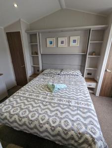 een slaapkamer met een bed met een teddybeer erop bij LOCATION LOCATION Beautiful Modern Frontline Caravan Haven Littlesea Weymouth in Weymouth