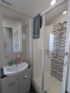 een badkamer met een wastafel en een douche bij LOCATION LOCATION Beautiful Modern Frontline Caravan Haven Littlesea Weymouth in Weymouth